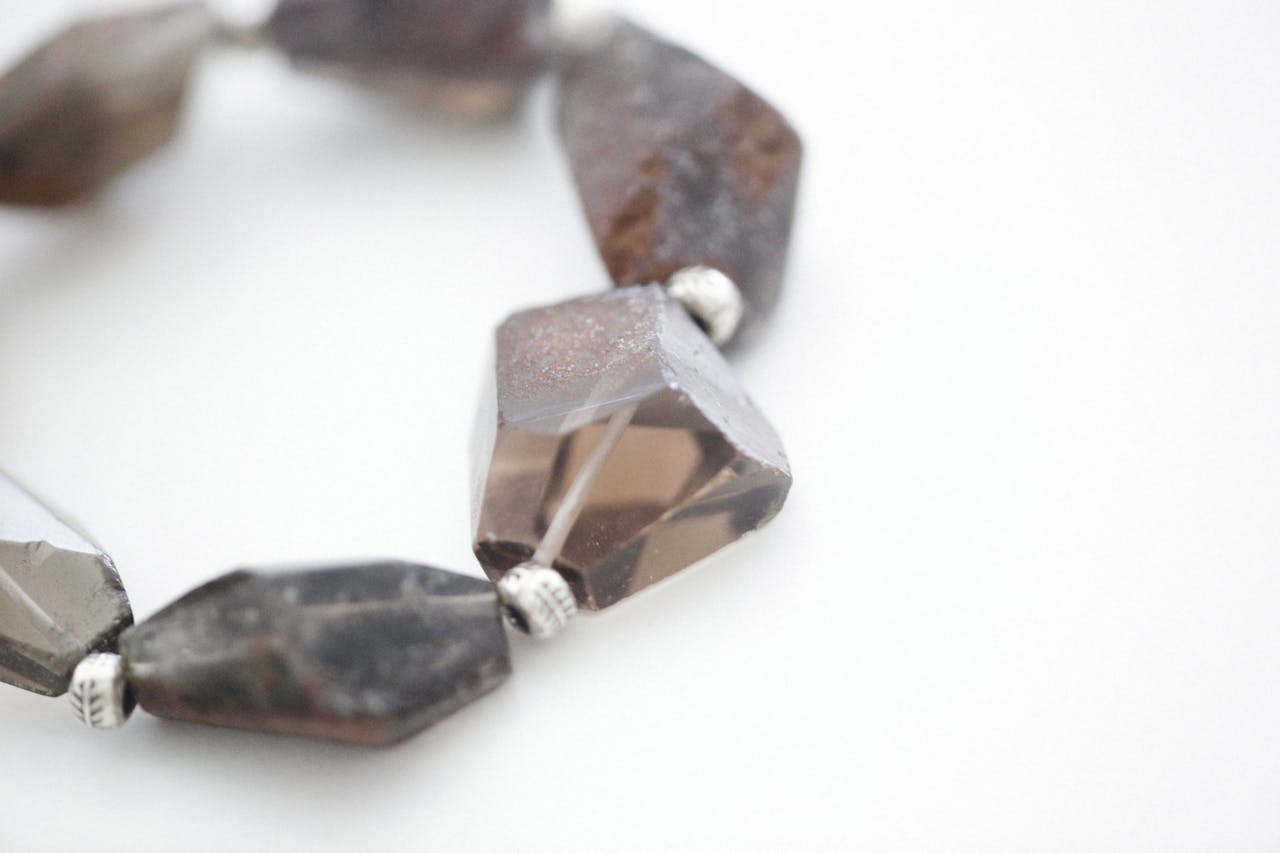 Close-up of a handcrafted quartz bracelet showcasing dark and light gemstones elegantly strung together.